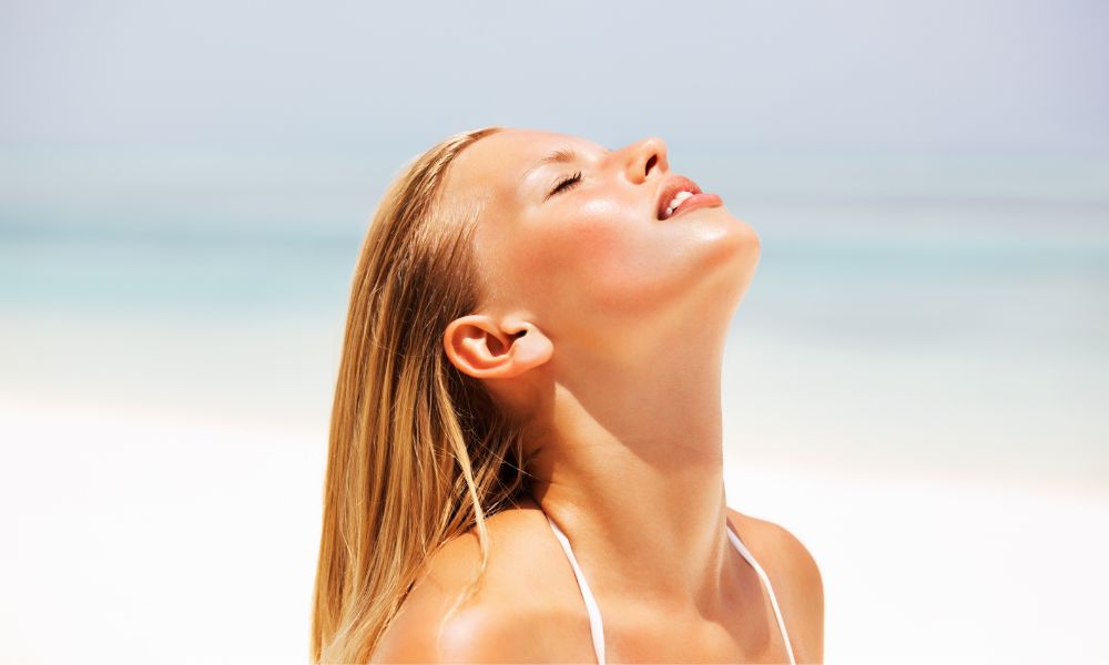 Girl sunbathing with sunscreen, one of the main types of product manufactured at the Biofarma Group's plant in San Pietro Viminario